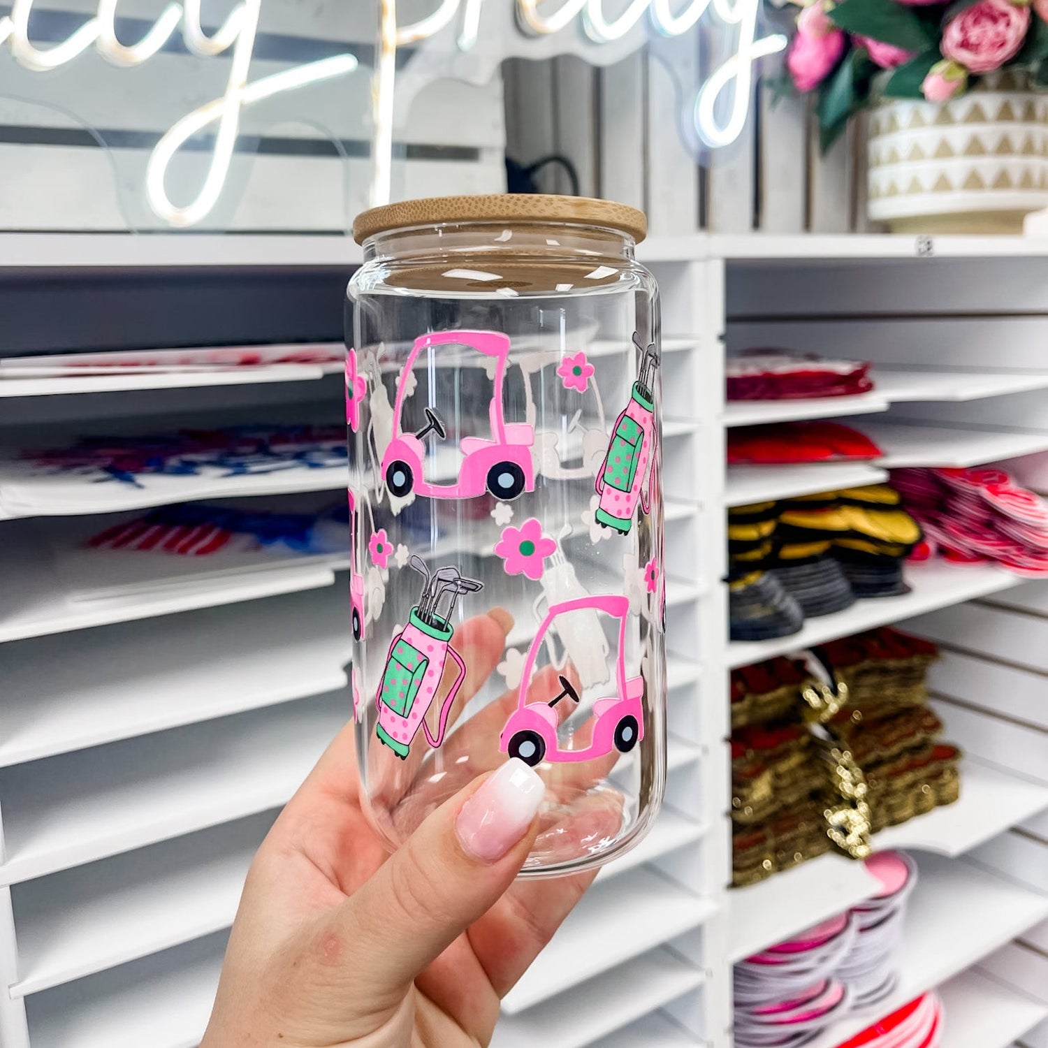 16 oz glass can featuring a golf themed UV DTF transfer with pink golf cart, flowers, and golf bag, showcasing a durable waterproof custom UV sticker wrap