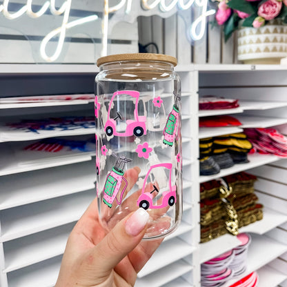 16 oz glass can featuring a golf themed UV DTF transfer with pink golf cart, flowers, and golf bag, showcasing a durable waterproof custom UV sticker wrap